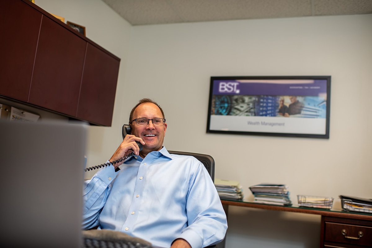 Man talking on the phone in an office, smiling